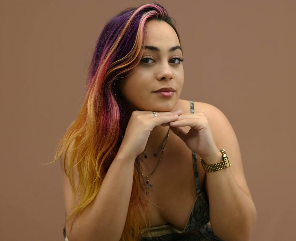 A woman with long purple hair and pink and yellow streaks